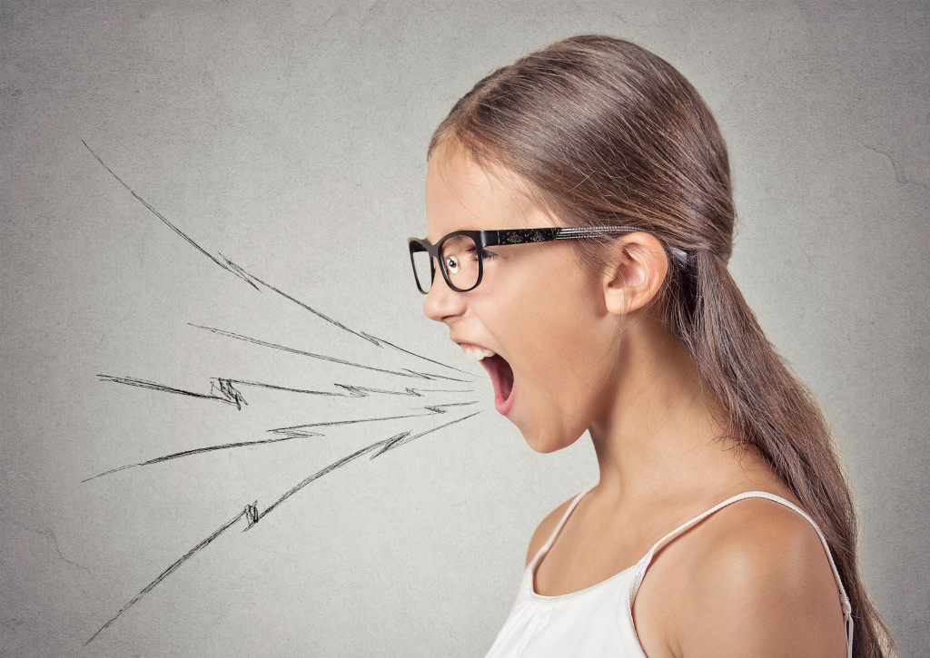 Side view profile portrait angry woman screaming wide open mouth hysterical isolated grey wall background. Negative human face expression emotion, bad feeling reaction. Conflict, confrontation concept