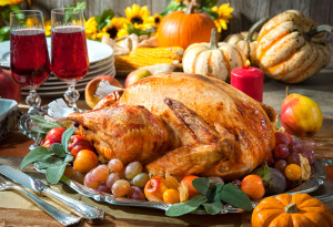 Thanksgiving dinner. Roasted turkey on holiday table with pumpkins, flowers and wine